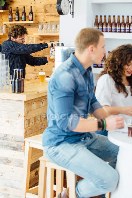 Hombre vertiendo cerveza en vidrio - foto de stock