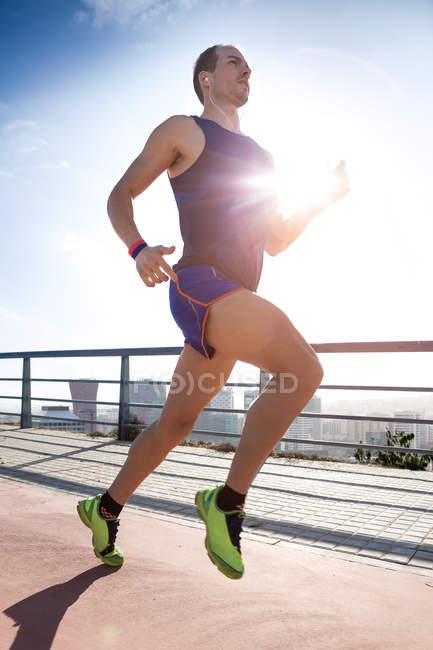 Handsome young man running in the park. — Stock Photo