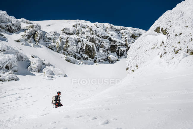 Homme grimpant sur la montagne enneigée — Photo de stock