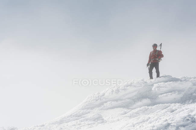 Escalador no topo da montanha nevada — Fotografia de Stock