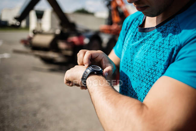 Deportista viendo el tiempo en los relojes de brazo - foto de stock