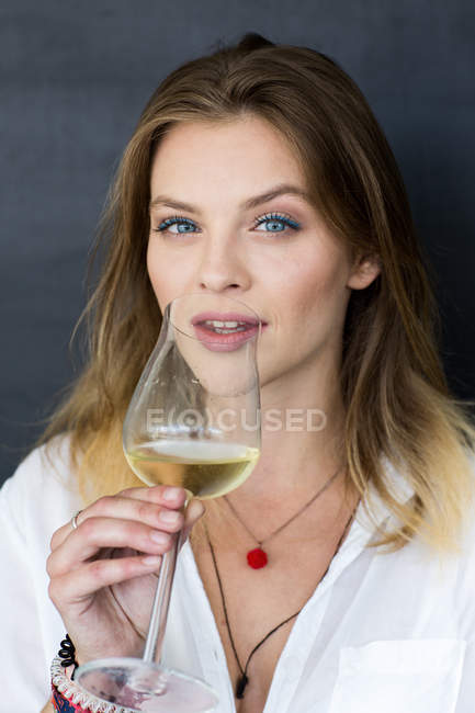 Junge Blondine trinkt Wein aus Glas — Stockfoto