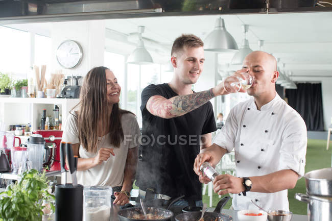 Chef drinking with help of student — Stock Photo