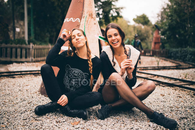 Young women sitting near wigwam — Stock Photo