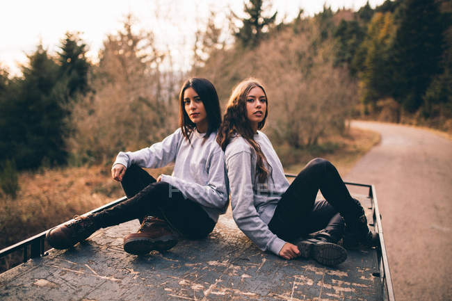 Junge Mädchen sitzen auf dem Autodach — Stockfoto