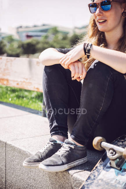 Скейтбордист сидит в парке — стоковое фото