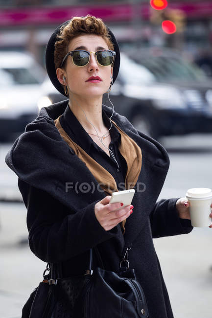 Frau mit Handy und Kaffee. — Stockfoto