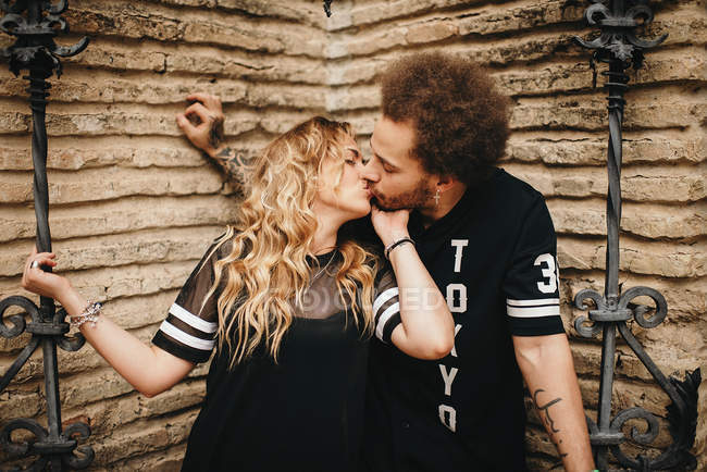 Embrasser couple au mur de pierre — Photo de stock