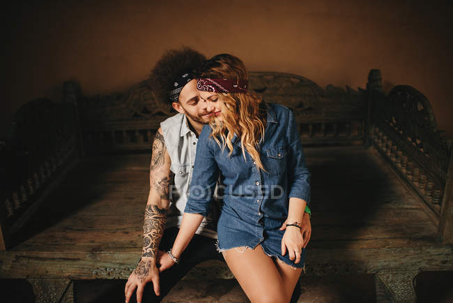 Hugging couple sitting on old bed — Stock Photo