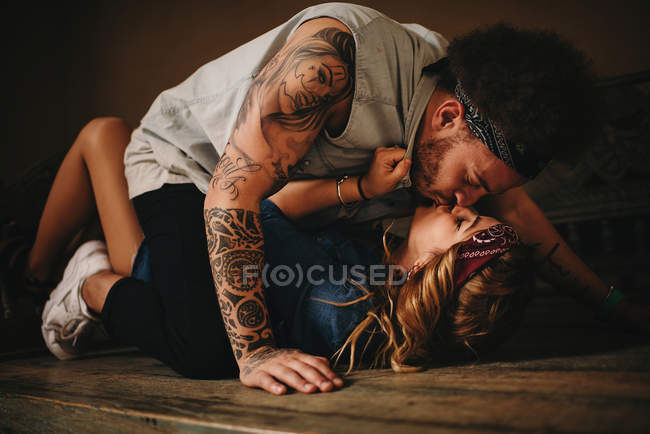 Casal beijando na cama de madeira — Fotografia de Stock