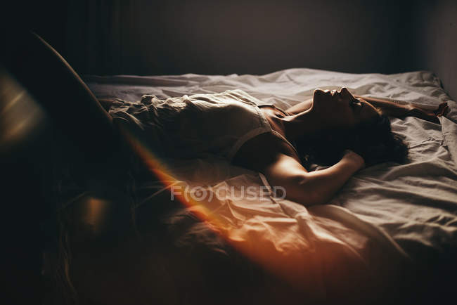 Чуттєва жінка лежить на ліжку — стокове фото