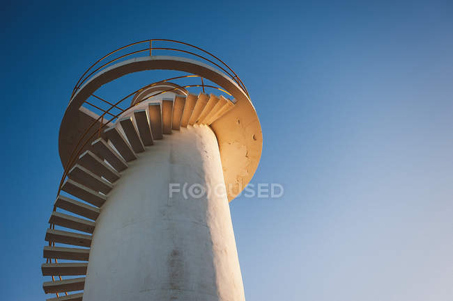 Белый маяк над голубым небом — стоковое фото