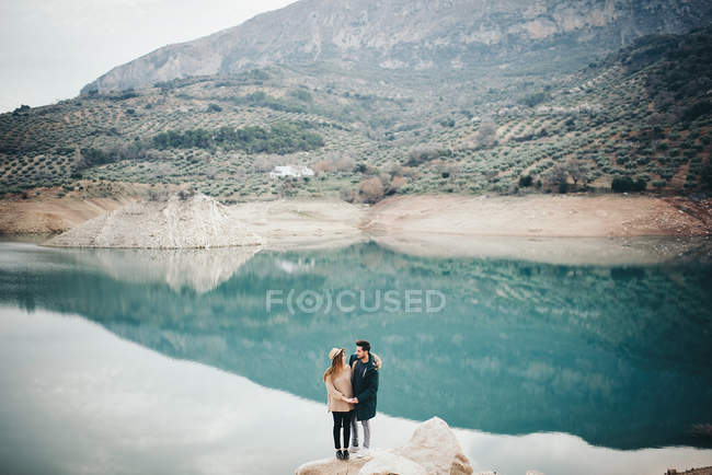 Casal adolescente contra de lago — Fotografia de Stock