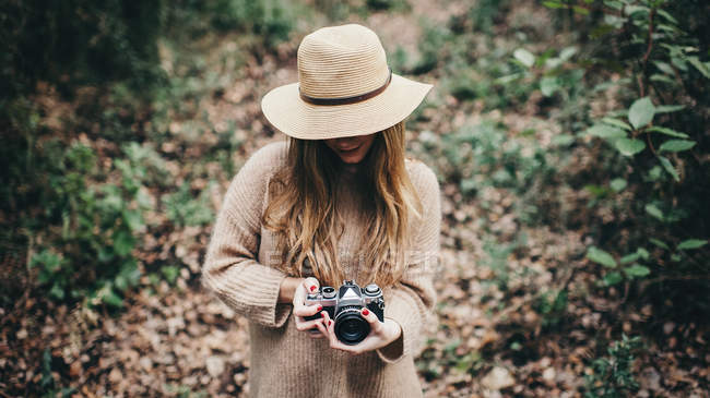 Stylish woman in hat with film camera — Stock Photo