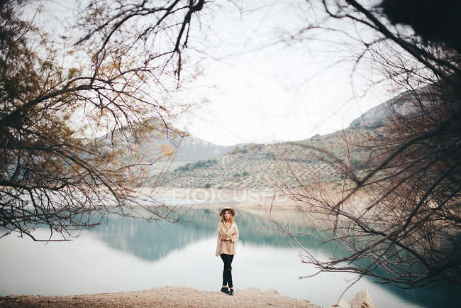 Femme en chapeau contre lac de montagne — Photo de stock