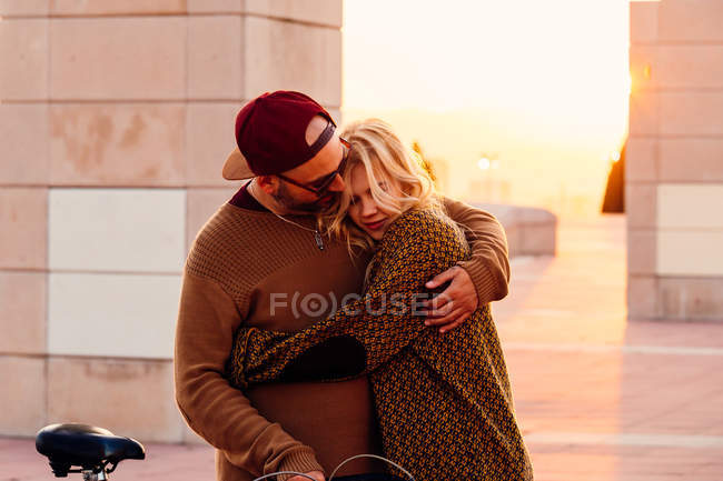 Casal abraçando na luz do pôr do sol — Fotografia de Stock