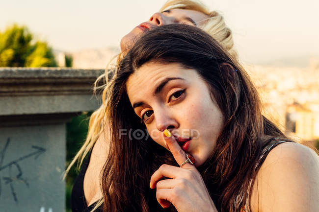 Chica sosteniendo el dedo en los labios - foto de stock