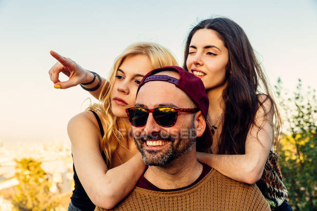 Duas meninas se apoiando no ombro do homem — Fotografia de Stock