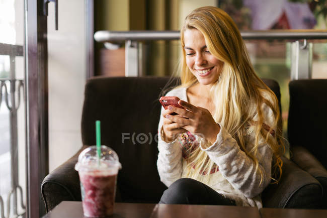 Улыбающаяся женщина с помощью мобильного телефона — стоковое фото