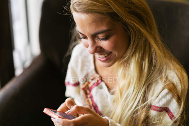 Femme souriante utilisant un téléphone mobile — Photo de stock