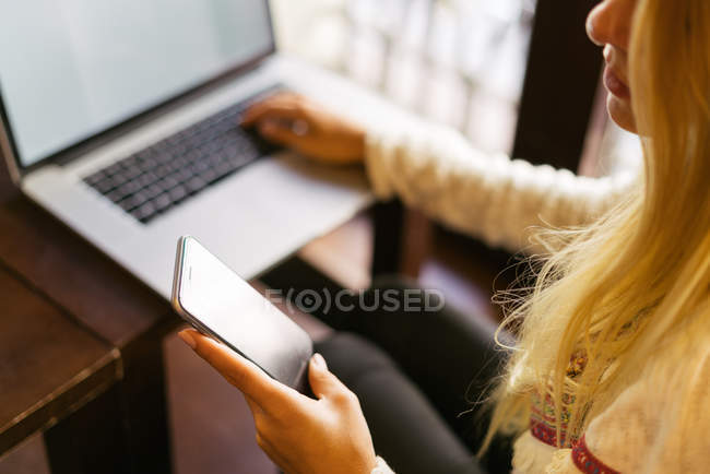 Woman with smartphone and laptop — Stock Photo