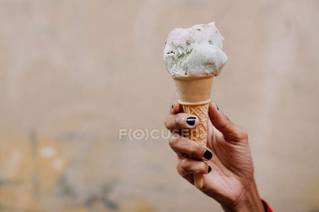 Mano femenina sosteniendo helado - foto de stock