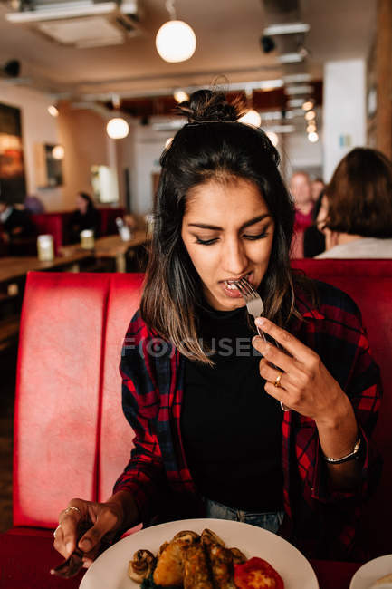 Девушка ест еду в кафе — стоковое фото
