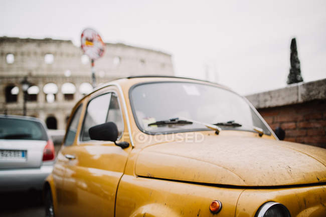Carro amarelo vintage estacionado na cena urbana — Fotografia de Stock