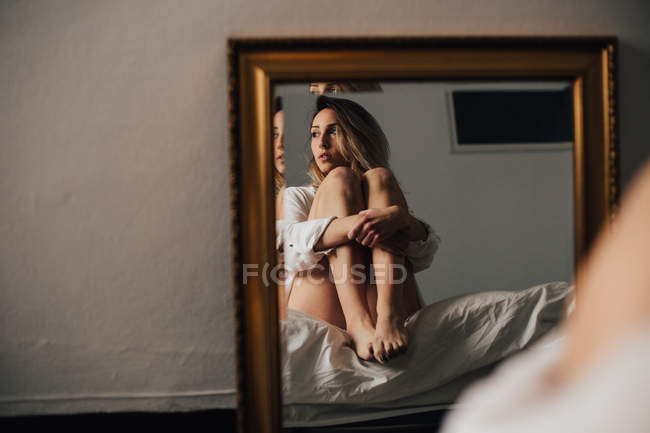 Femme étreignant ses genoux — Photo de stock