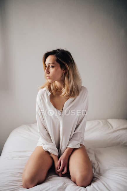 Frau sitzt auf Bett — Stockfoto