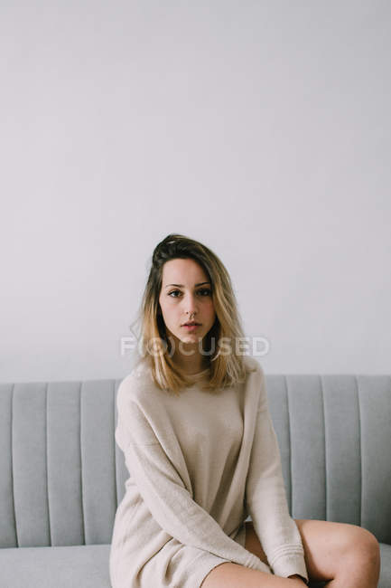 Young female sitting on sofa — Stock Photo