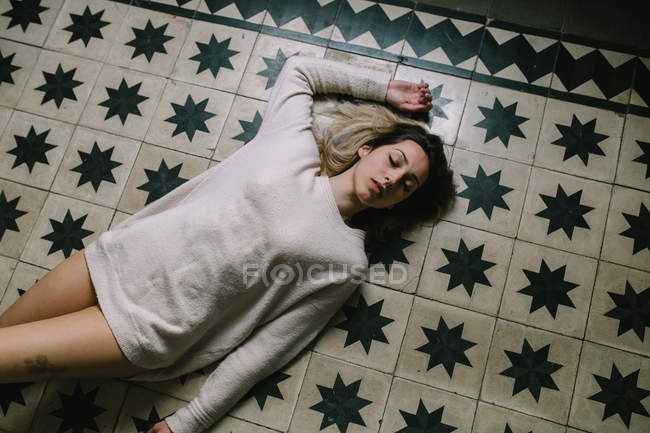 Mujer durmiendo en el suelo - foto de stock