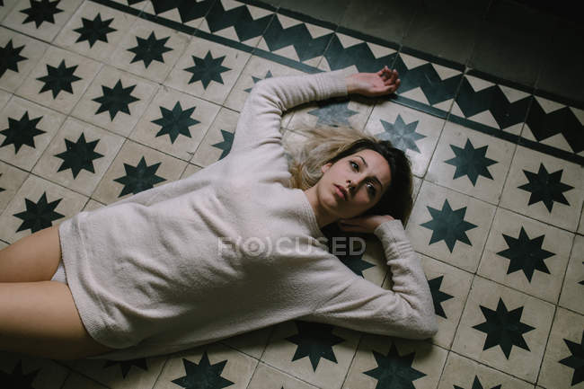 Жінка лежить на підлозі — стокове фото