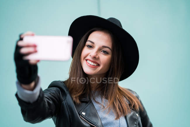 Woman wearing hat taking selfie. — Stock Photo