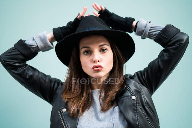 Молода жінка торкається капелюха — стокове фото