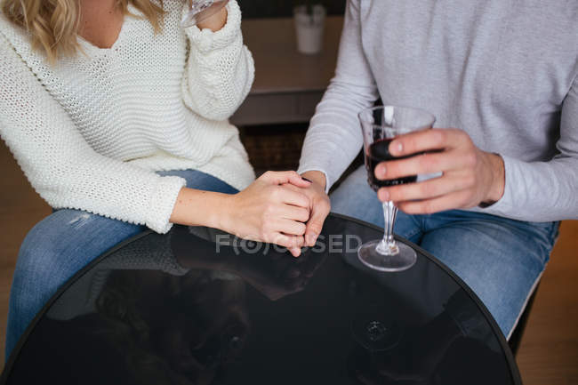 Пара держатся за руки и пьют вино — стоковое фото