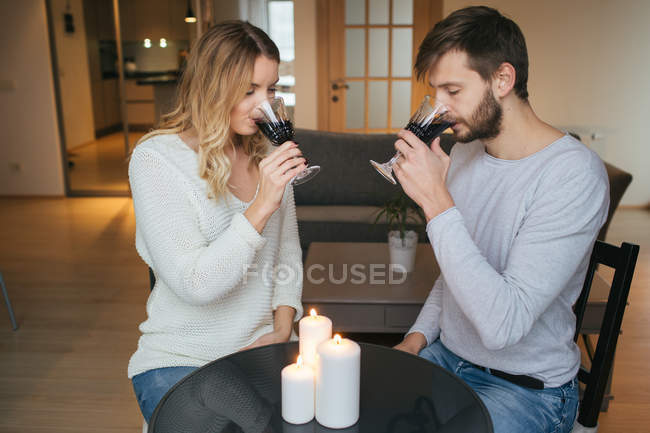 Couple holding hands ad drinking wine — Stock Photo