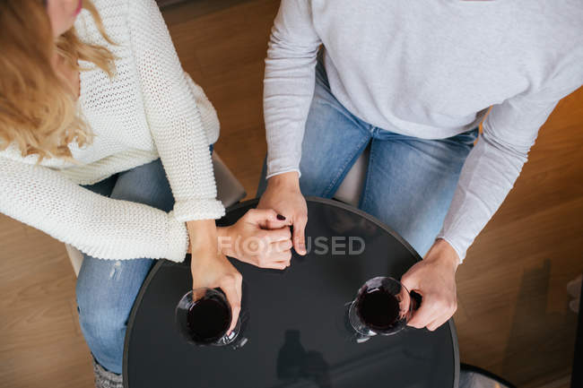 Paar hält Händchen und trinkt Wein — Stockfoto