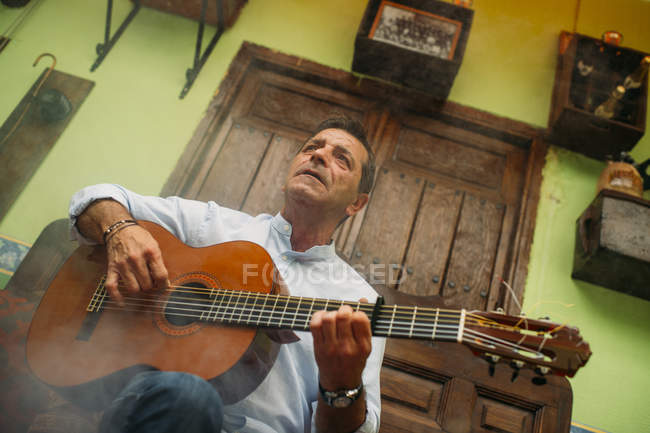Портрет літнього чоловіка, який грає на гітарі — стокове фото