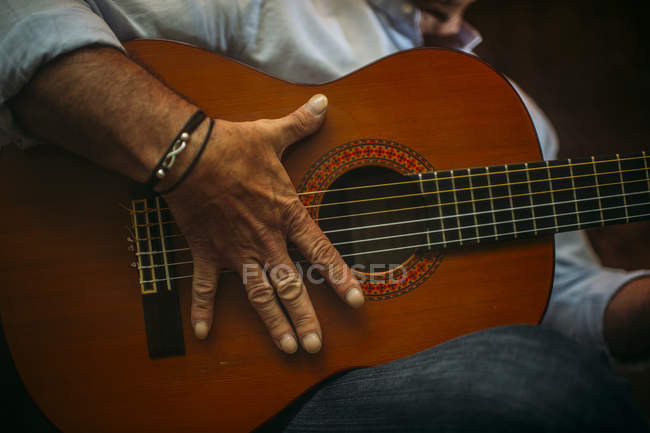 Пожилой человек играет на гитаре — стоковое фото
