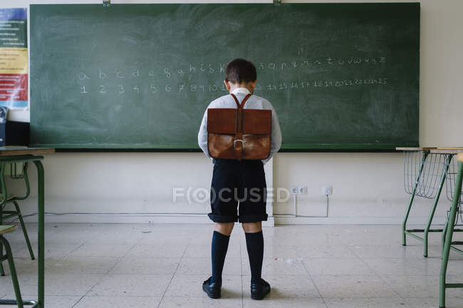 Хлопчик зі шкільною сумкою в класі — стокове фото