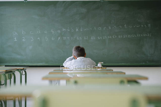 Школьник за столом в классе — стоковое фото