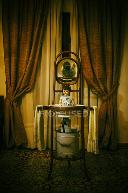 Raccapricciante bambola sorridente nel lavandino vintage — Foto stock