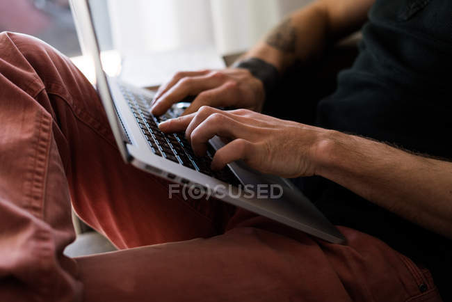 Mãos de pessoa digitando um laptop — Fotografia de Stock