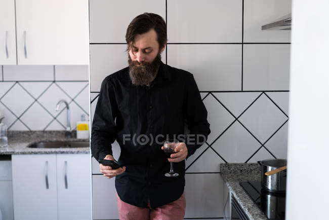 Homme avec téléphone et vin — Photo de stock