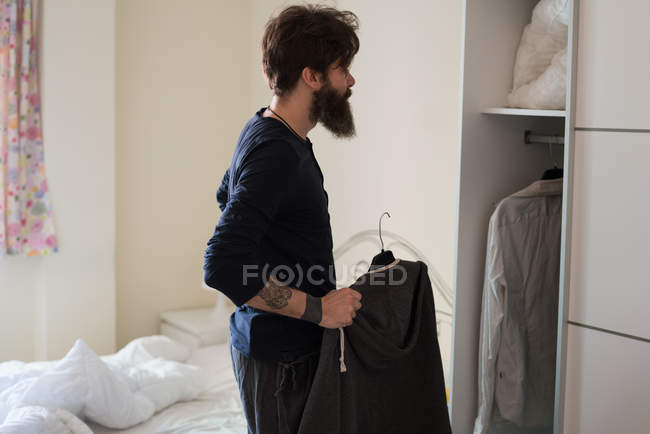 Man choosing shirt in morning — Stock Photo