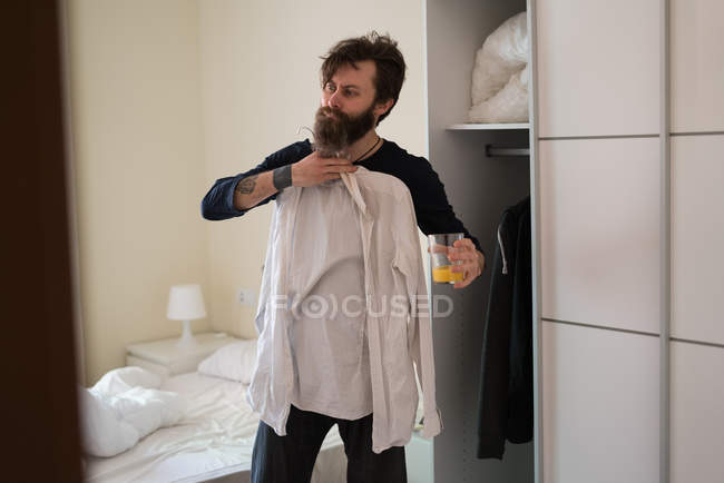 Мужчина выбирает рубашку утром — стоковое фото