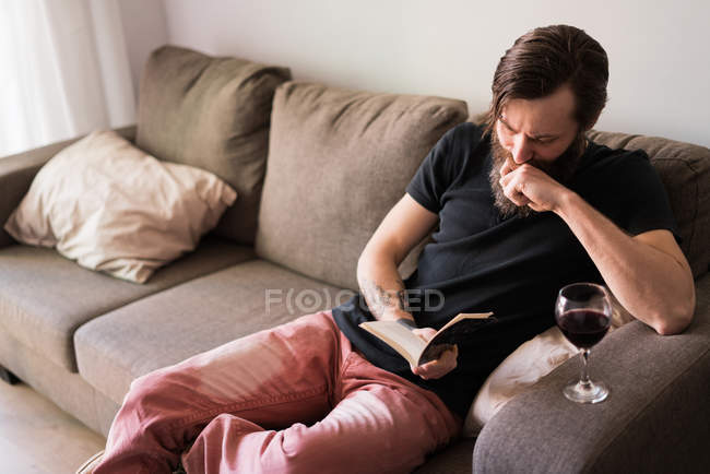 Hombre leyendo un libro en casa - foto de stock