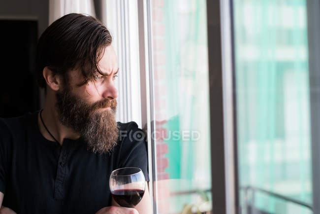 Hombre reflexivo con copa de vino - foto de stock
