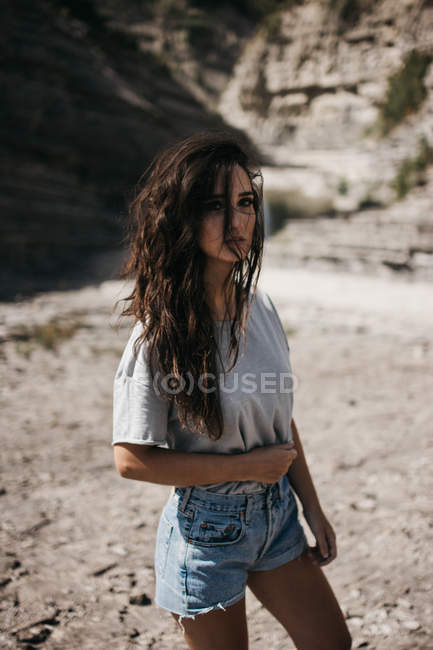 Молода жінка стоїть біля скелі — стокове фото